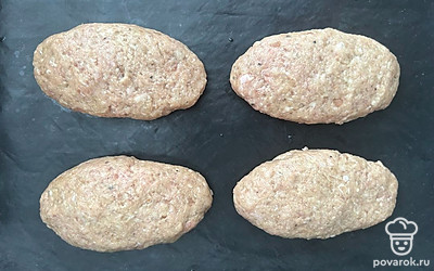 Из фарша сформируйте котлеты. Выложите на противень, застеленный ковриком. Отправьте в разогретую до 180 градусов духовку на 25 минут.