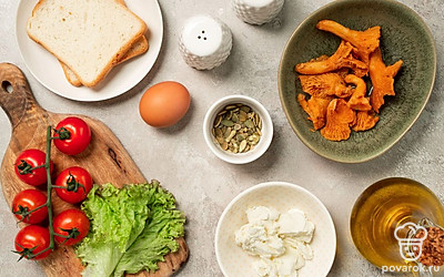 Тостовый хлеб подсушите на сухой сковороде с обеих сторон до образования хрустящей корочки. Яйцо промойте, обсушите и приготовьте пашот в кипящей воде с уксусом. Помидоры, салат и лисички промойте, просушите. Черри заранее нарежьте дольками. Также возьмите сковороду для жарки.