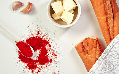 Чеснок почистите и измельчите в прессе. Багет нарежьте ломтиками толщиной 1 см или чуть больше. Петрушку помойте и обсушите, мелко покрошите. Сливочное масло достаньте из холодильника за 1 час до приготовления багета. Разогрейте духовку до 180 градусов. Подготовьте фольгу для запекания и миксер.