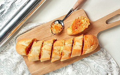 Запеките багет в фольге. Из ломтиков сформируйте багет, прижимая их друг к другу, заверните плотно в фольгу. Запекайте в разогретой до 180 градусов духовке в течение 20 минут.