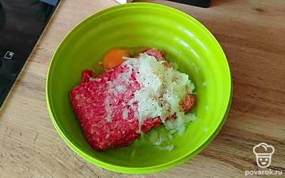 В размороженный фарш разбейте 1 яйцо. Измельчите луковицу. Чтобы котлеты получились еще более сочные, можете добавить 2 луковицы. Можете натереть лук на терке, но лучше растереть его в пюре с помощью блендера или измельчителя. Посолите по вкусу, добавьте любимые специи. Я добавляю лишь немного молотого перца. Хорошенько вымешайте фарш. 