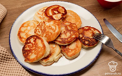 Подавайте готовые оладьи, по желанию дополнив сметаной или любимыми топингами.