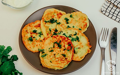 Разложите оладьи по порционным тарелкам и украсьте нарезанным зеленым луком.