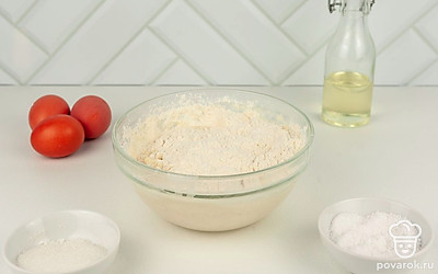 Просейте муку и тоненькой струйкой добавьте в смесь. Начните с 200 мл и добавьте еще 50 мл, если тесто жидкое. Оно должно густотой напоминать жирную сметану. Разбейте комочки тщательным перемешиванием.