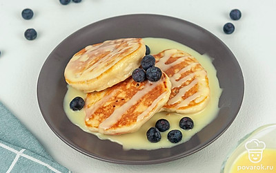 Подайте к оладьям сгущенное молоко, свежие ягоды: чернику, голубику, малину или смородину, молоко или ароматный чай.