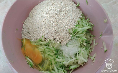 Кабачок натрите на крупной терке. Добавьте соль, немного сахара и овсяные хлопья. Дайте смеси постоять 10-15 минут, чтобы хлопья набухли. По желанию, измельчите хлопья в кофемолке. Все перемешайте.