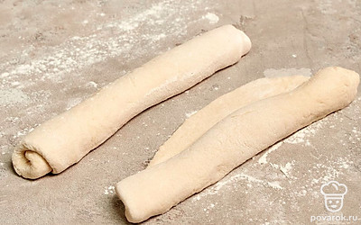 Сформируйте багеты. Разделите тесто на 4 части. Каждую часть раскатайте в лепешку, скрутите ее в рулет и руками растяните багет до нужной длины.