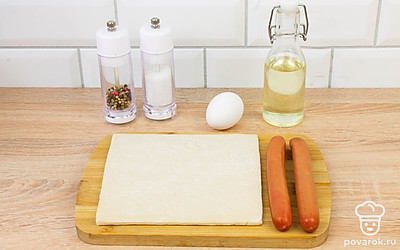 Разморозьте слоеное тесто. Очистите сосиски от упаковки. Разогрейте духовку до 180°С.