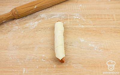 Заверните сосиски в тесто. Таким образом сформируйте все хот-доги.