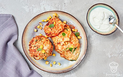 Готовые оладьи из куриного филе и кукурузы подавайте вместе со сметаной.