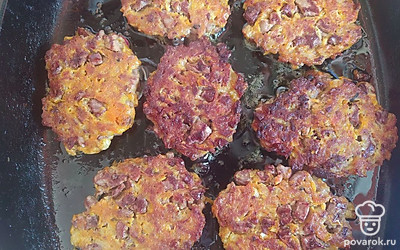 С помощью столовой ложки выложите тесто в виде круглых оладий. Жарьте на среднем огне по 3 минуты с каждой стороны. Выложите готовые оладьи на тарелку, застеленной бумажной салфеткой, и дайте лишнему маслу стечь. После этого подавайте блюдо в красивой тарелке со сметаной.