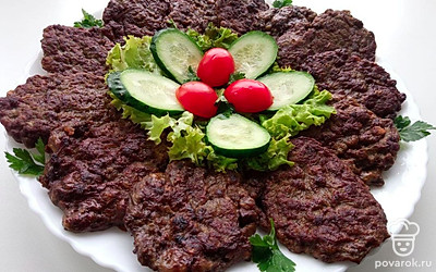 Выложите оладьи на тарелку, в серединку поставьте любую зелень, тонко нарезанные огурцы и помидоры черри. Подавайте горячими.