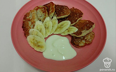 Подавайте оладьи со сметаной и нарезанным кружочками бананам.