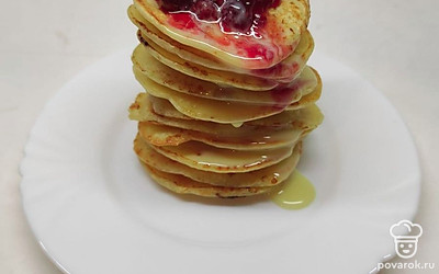 Выложите все оладьи в стопку. Полейте сгущенным молоком и вареньем.