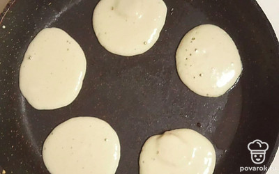 Разогрейте подсолнечное масло на сковороде и на нее выложите тесто с кусочками банана. Выпекайте оладьи с обеих сторон до золотистой корочки.