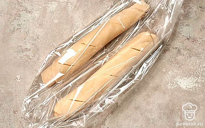 Испеките багет в рукаве. Аккуратно поместите багеты в рукава для запекания, завяжите их, положите на противень. Оставьте на 30 минут в теплом месте. Поставьте багеты в холодную духовку, включите нагрев на 200 градусов. Выпекайте багеты 30 минут.