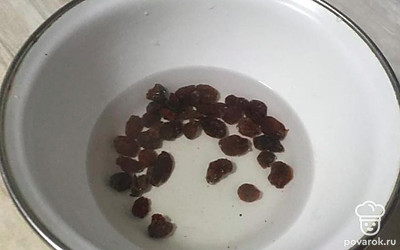 Горсть изюма промойте и положите в чашу. Промытый изюм залейте кипятком, чтобы вода его покрывала.