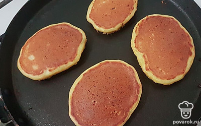 Разогрейте сковороду на среднем огне, смажьте растительным маслом и начните выпекать оладьи, выкладывая тесто столовой ложкой.