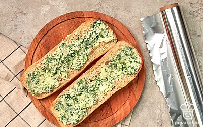 Подготовьте багет к обжарке на гриле. Багет разрежьте пополам, в каждой половине сделайте глубокий надрез. Уберите большую часть мякиша. В срез выложите начинку, плотно заверните багет в фольгу.