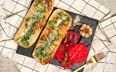 По окончании приготовления освободите багеты от фольги, подавайте горячими с овощами гриль.