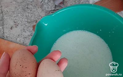 В ёмкость добавьте молоко, к нему 2 яйца.