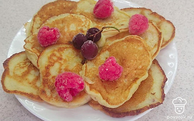Выложите на тарелку оладьи и положите малину.