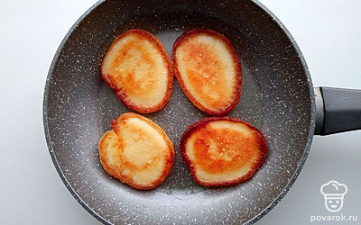 Перелейте из банки в миску сгущенное молоко. Вбейте яйца и добавьте соль, взбейте миксером. Влейте ложку масла. Муку смешайте с разрыхлителем. Добавьте в миску и замесите тесто. Выкладывайте по ложке теста на смазанную маслом сковороду и пеките оладьи на медленном огне с двух сторон до румяной корочки.