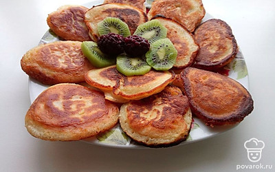 Готовые оладьи переложите в блюдо и украсьте фруктами.