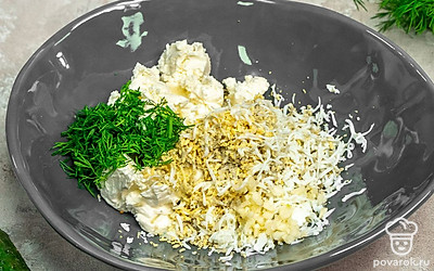 Сделайте начинку. Вареные яйца натрите на средней терке. В миске смешайте яйца, мелко нарезанный укроп, творожный сыр и измельченный чеснок.
