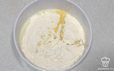 Насыпьте муку с растопленным маслом и перемешайте.