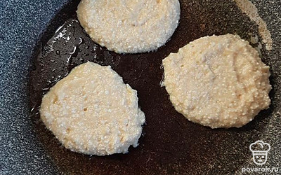 Столовой ложкой выкладываем оладьи на сковороду. Накрываем их крышкой, и жарим на среднем огне до подрумяненности.