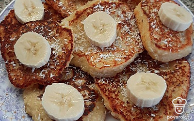 Получаются вот такие простые и милые оладьи. Я посыпаю их кокосовой стружкой и добавляю банан. Можно подавать такое блюдо в качестве десерта, полив сгущенкой. Приятного аппетита!