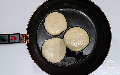 Разогрейте сковородку на нем 20 г растительного масла. Выложите оладьи ложкой на разогретую сковороду и жарьте по 2-3 минуты.