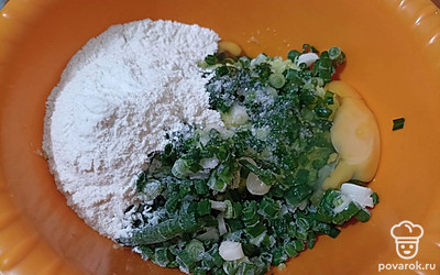 В миске смешайте кабачок, зеленый лук, яйца и муку.