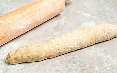 Сформируйте багеты. Стол посыпьте мукой и выложите на него тесто. Растяните его в прямоугольник и сложите по бокам от края к центру. Таким же образом сложите верхний и нижний края к центру. Сложите тесто таким образом еще два раза. Разделите тесто на две части и сформируйте из них багеты. Уложите багеты в форму для выпечки и оставьте на 30 минут.