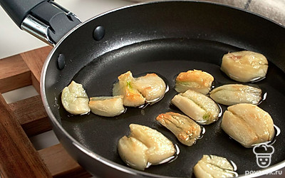 Приготовьте чесночное масло. Налейте на сковороду половину масла, нагрейте, выложите половину чесночных слайсов. Обжарьте на среднем огне до румяности около 2 минут. Затем переверните дольки на другую сторону, обжарьте столько же времени. После этого чеснок уберите со сковороды.