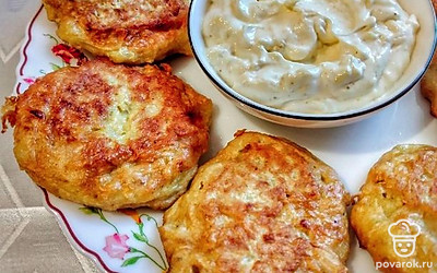 Подавать оладьи с соусом из сметаны с измельченным чесноком.