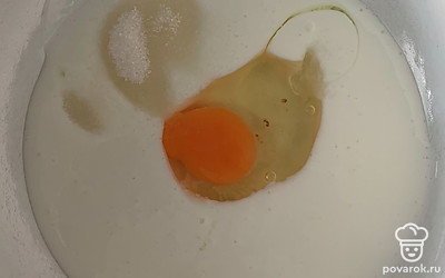 В теплый кефир добавляем сахар и яйцо.