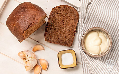 Нарежьте хлеб ровными ломтиками шириной около 1 см. Почистите и выдавите через пресс чеснок. Помойте и мелко нарежьте кинзу для подачи.