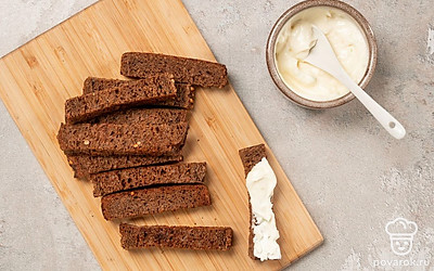 Приготовьте чесночный соус. Смешайте майонез с чесноком, посолите по вкусу. Смажьте тосты получившимся чесночным соусом.