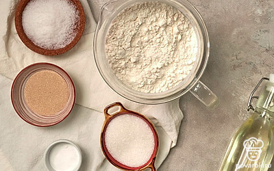 Отмерьте необходимое количество продуктов. Муку просейте через сито. Воду для теста подогрейте. Противень застелите пергаментной бумагой.