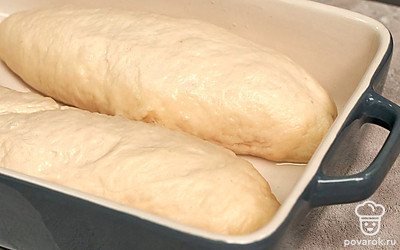 Отварите и испеките багеты. Возьмите большую кастрюлю, налейте 2 л воды, добавьте соду, вскипятите. В кипяток выложите заготовки и варите в течение 1 минуты, постоянно переворачивая изделия. Отваренные заготовки выложите на противень, сделайте надрезы по диагонали, отправьте выпекаться на 30 минут при температуре 180 градусов.