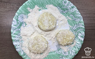 Обваляйте получившиеся лепешки в муке с двух сторон.