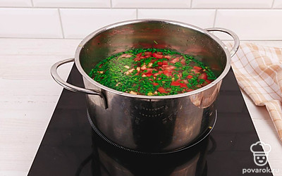 Затем добавьте нарезанную зелень, кусочки помидора, консервированный горошек и кукурузу. Варите до готовности ингредиентов.