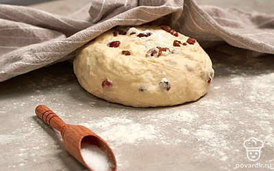 Займитесь тестом. В дрожжевую смесь насыпьте часть муки, перемешайте, всыпьте еще порцию муки, посолите, выложите изюм, еще раз перемешайте, добавьте 1 ст.л. масла, перемешайте. Всыпьте остатки муки, замесите мягкое тесто. Прикройте емкость полотенцем и оставьте в тепле на 30 минут.