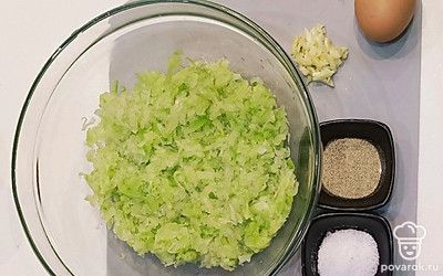 Приготовьте все необходимые продукты. Кабачок среднего размера очистите от кожуры, удалите семена, протрите на терке. Отдавите лишнюю жидкость руками. Чеснок измельчите удобным способом. Можете добавить свои любимые специи, я иногда приправляю сухими травами.