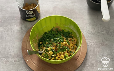 Порежьте зеленый лук и добавьте 200 грамм кукурузы в смесь.