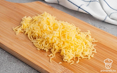 Очистите яйцо, разрежьте его на две части, выньте желток чайной ложкой. Мелко покрошите яичный желток и грецкие орехи. Натрите сыр на терке.