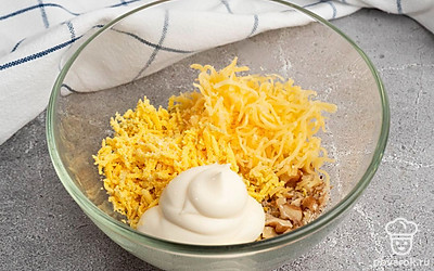 Соедините в отдельной посуде сыр, яичный желток, грецкие орехи, майонез, соль и перец. Тщательно все перемешайте вместе.