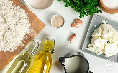 Нагрейте молоко до 40 градусов. Заранее смешайте дрожжи с мукой. Если дрожжи необходимо смешивать с жидкостью — добавьте их в теплое молоко. Приготовьте начинку для багета: помойте и измельчите зелень петрушки, соедините ее с оливковым маслом, солью и чесноком, перетрите и оставьте в стороне. Сыр заранее натрите на терке или разомните вилкой.